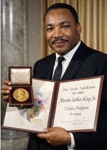 Dr. Martin Luther King Jr. holding his 1964 Nobel Peace Prize medal and certificate